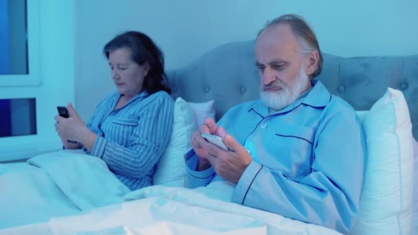 Moderna coppia in pensione leggere notizie su smartphone, seduto a letto, tecnologia — Video Stock