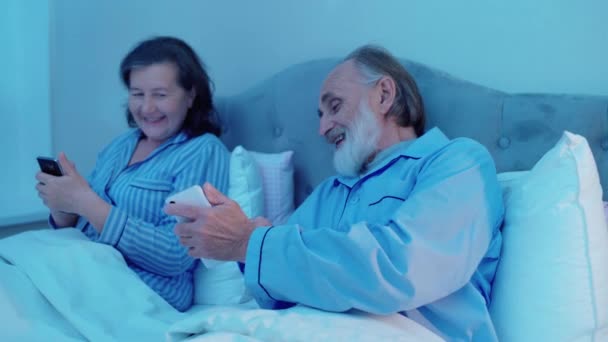 Feliz marido y mujer viendo vídeo en el teléfono inteligente, divertirse juntos, el amor — Vídeos de Stock