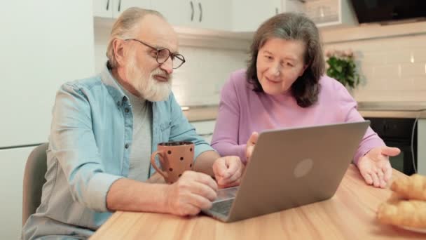 Positief volwassen stel kijken naar foto 's op laptop samen, vrije tijd thuis — Stockvideo