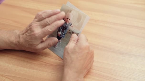Elderly female hands stroking granddaughter's photos, family connection, love — Stock Video