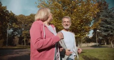 Gülümseyen olgun arkadaşlar birlikte koşuyorlar, kardiyo eğitimi, açık havada dinlenme.