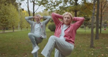 Çift dirsek dirseğe mekik çekiyor, antrenmandan önce ısınıyor, spor yapıyor.