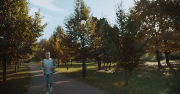 นักกีฬาอาวุโสรู้สึกเจ็บหน้าอกวิ่งในสวนสาธารณะ หายใจถี่ สุขภาพ — วีดีโอสต็อก