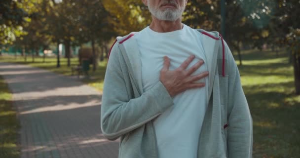 Oudere mannelijke loper die last heeft van ongemak op de borst, ischemische hartziekte — Stockvideo