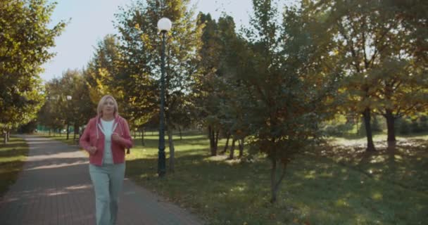 Kobieta odczuwająca ból brzucha, jogging w parku, skurcze żołądka, opieka zdrowotna — Wideo stockowe