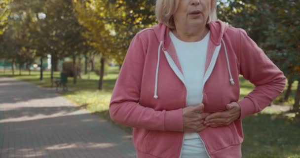 Oudere vrouw die lijdt aan plotselinge maagpijn, symptoom van gastro-enteritis — Stockvideo
