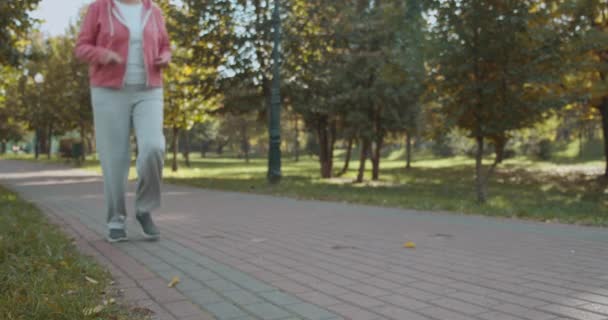 膝の痛み、筋肉の緊張、関節の炎症を感じる高齢女性のランナー — ストック動画