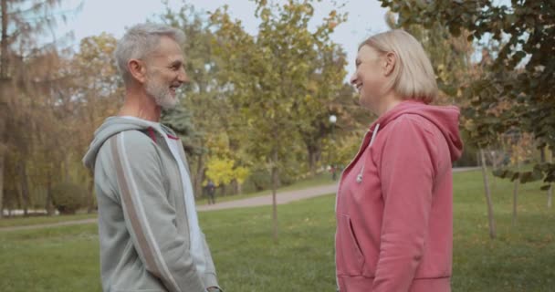 Lächelnder Mann kommuniziert mit blonder Seniorin, gemeinsame Interessen, Sport — Stockvideo