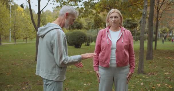 Professeur de conditionnement physique en colère parler à une femme âgée, faire des squats, la motivation — Video