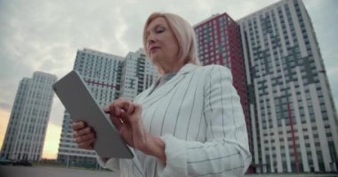 Bayan patron, konut kompleksinin yakınındaki tablette yazıyor, daire alımı, kira.