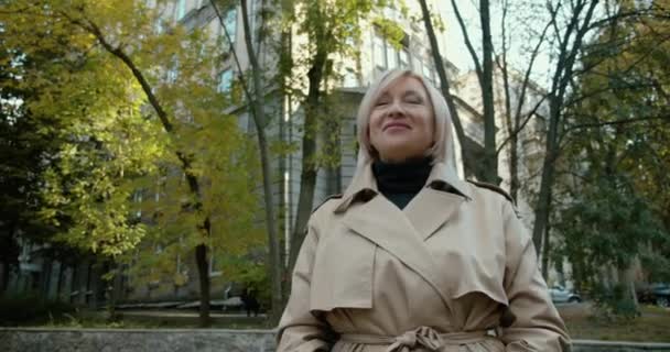 Linda loira envelhecida fêmea desfrutando de passeio de outono no parque e sorrindo, bom humor — Vídeo de Stock
