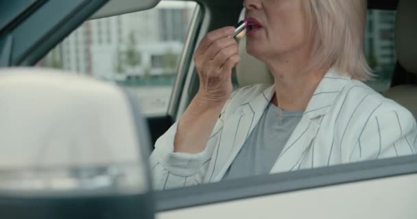 Donna bionda che applica il trucco in automobile, si mette il rossetto e sorride — Video Stock