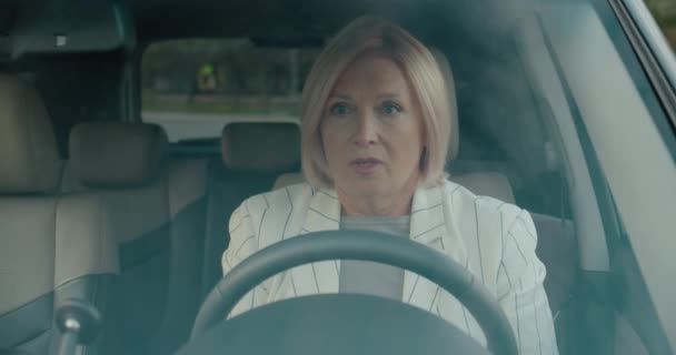 Депрессивная пожилая женщина плачет в машине, кладет руки на колесо, проблемы, стресс — стоковое видео