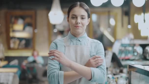 앞치마를 입고 카메라 앞에서 웃고, 팔을 접고, 식당 사업을 하는 행복 한 젊은 여성 — 비디오