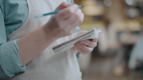 Camarera tomando el orden en el restaurante, escribiendo en bloc de notas, responsabilidades laborales — Vídeos de Stock