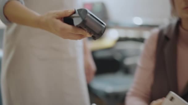 Cliente femenino que paga con teléfono inteligente en la cafetería, terminal de tarjetas de crédito, tecnología — Vídeo de stock