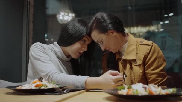 Brunette mother and daughter touching foreheads, sitting in cafe, family support — Stock Video