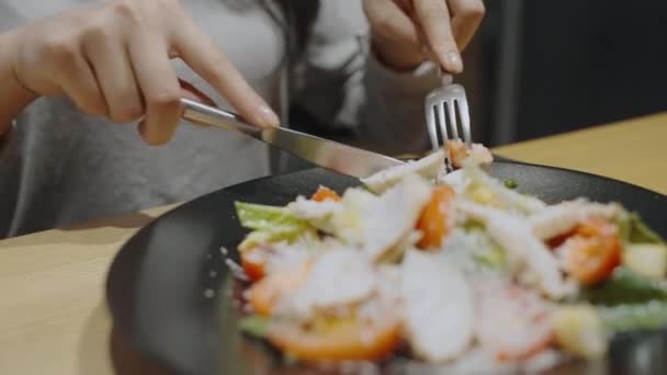 Mujer comiendo ensalada fresca con tenedor y cuchillo, cena en restaurante, pérdida de peso — Vídeos de Stock