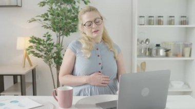 Boyun kaslarını esneten, dizüstü bilgisayarla çalışan, sağlık görevlisi bekleniyor.