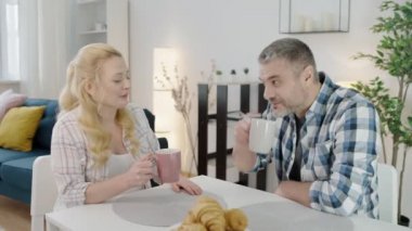 Genç hamile kadın midesi bulanıyor, sabahları kocasıyla çay içiyor.