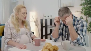 Kızgın bir kadın mutfakta kocasına bağırıyor. Hormonal değişimler geçiriyor.