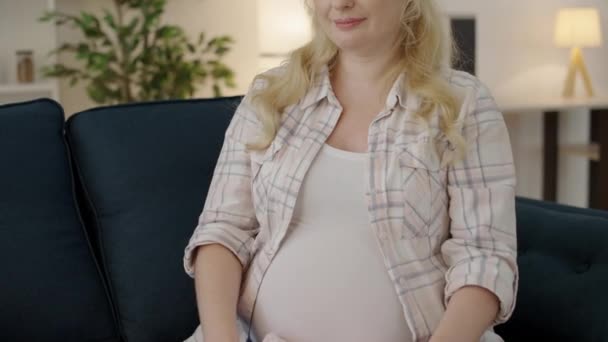Positivo esperando feminino segurando roupas de bebê rosa, felicidade gravidez, amor — Vídeo de Stock