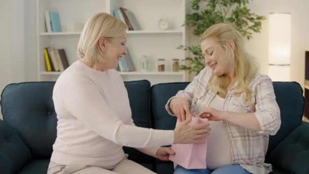 Aufgeregt werdende Frau erhält Neugeborenenkleidung von Mutter, Familienpflege — Stockvideo