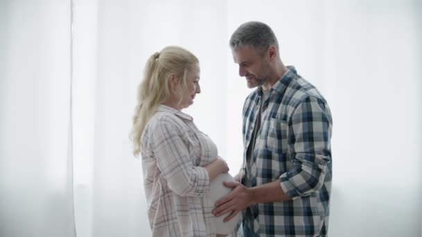 Marido feliz acariciando a barriga da esposa, ouvindo os chutes do bebê, futuros pais — Vídeo de Stock