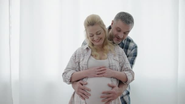 Vidám férj ölelés terhes feleség, boldog jövőbeli szülők, kapcsolat — Stock videók