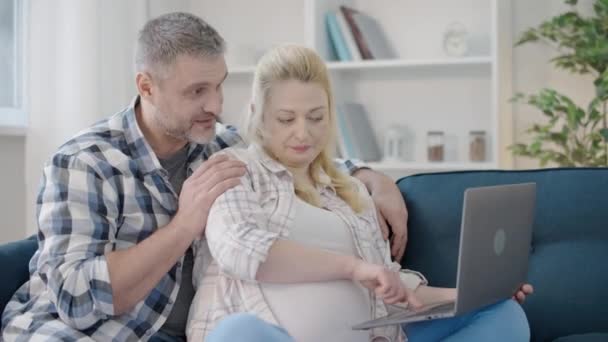 A szülők online vásárlása laptoppal, babaruhák vásárlása — Stock videók