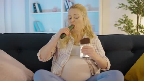 Éhező vár nő harapás édes csokoládé és uborka, élvezi az ételt — Stock videók
