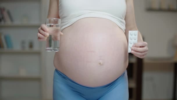 Těhotná žena drží pilulky a sklenici vody, léky na předpis, zdraví — Stock video