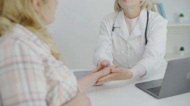 Steteskoplu mutlu jinekolog klinikte hamile genç bir kadını destekliyor.