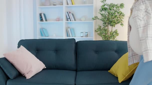 Jeune femme enceinte ressentant des maux de dos, assise sur le canapé à la maison, soins de santé — Video