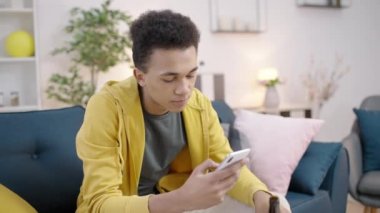 Genç adam bira içiyor, akıllı telefon kullanıyor, ergenlik çağında, kötü alışkanlıklar ediniyor.