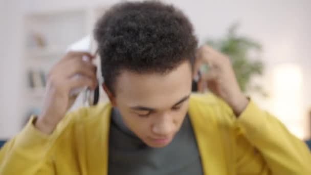 混合种族的青少年 戴着耳机 在智能手机上听音乐 — 图库视频影像