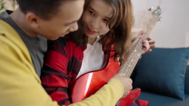 教女朋友弹吉他 学和弦 学业余爱好的年轻人 — 图库视频影像