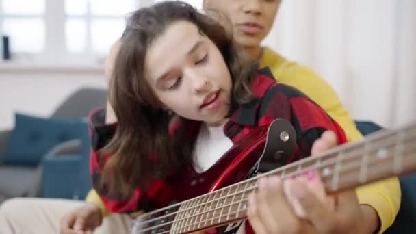 Karışık Irktan Bir Genç Kız Arkadaşına Evde Akustik Gitar Çalmayı — Stok video