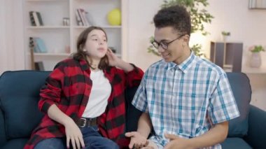 Aktif genç kız kanepede melez, inek bir adamla konuşuyor.