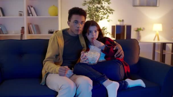 Multiethnische Teen Paar Horrorfilm Ansehen Verängstigte Mädchen Umarmen Männlichen Freund — Stockvideo