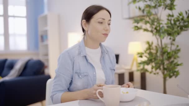 Усміхнена Молода Жінка Насолоджується Їжею Сидить Кухонним Столом Сніданком — стокове відео