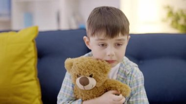 Üzgün çocuk oyuncak ayıya sarılıyor, negatif duygular, kötü anılar, sorun