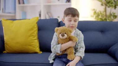 Ağlayan çocuk, oyuncak ayıyı tutan, yalnız hisseden, çocuğun davranışı.