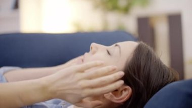 Genç kadın masaj tapınakları, baş ağrısı, kanepede yatmak, sağlık.