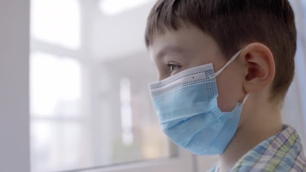 Kleine Jongen Met Beschermend Masker Kijkend Uit Het Raam Gezondheidszorg — Stockvideo