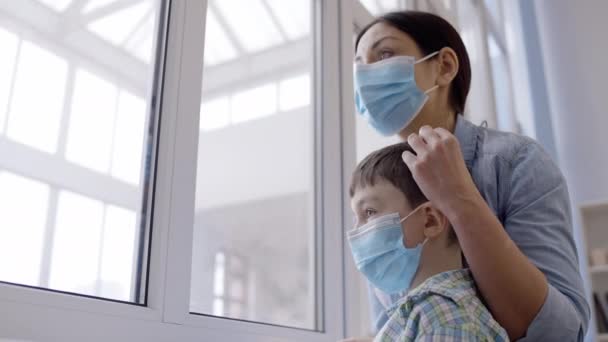 戴口罩的爱母亲抚摸儿子的头 在病毒大流行时进行检疫 — 图库视频影像