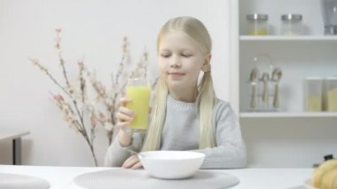 Genç kız taze meyve suyu içiyor ve gülümsüyor, sağlıklı beslenme ve vitaminler.