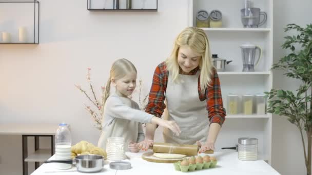 女儿在面团里加面粉 帮助妈妈在厨房里做饼干 — 图库视频影像