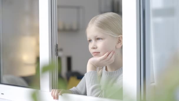 Meraklı Küçük Kız Pencereden Dışarı Bakıyor Evde Oturuyor Ailesini Bekliyor — Stok video