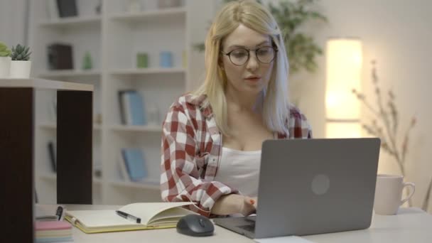 Atento Freelancer Femenino Gafas Trabajando Laptop Casa Tomando Notas — Vídeos de Stock